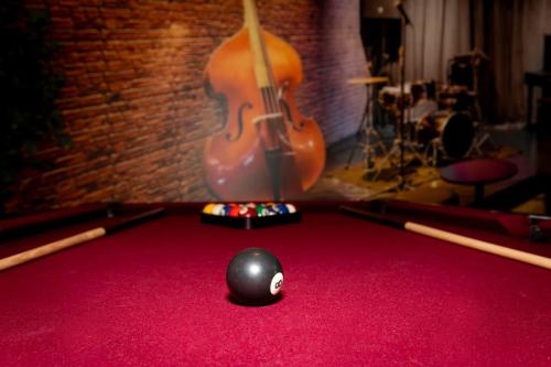a pool table with a cue ball and a guitar at The Jazz Club Downtown Sandusky in Sandusky