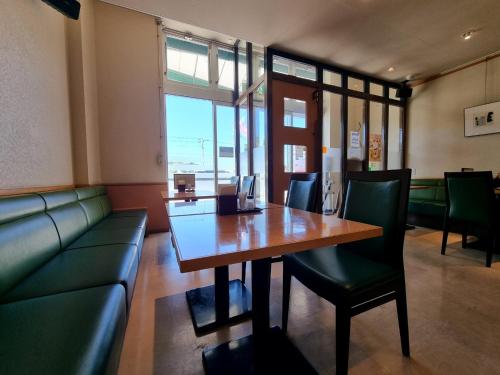 a dining room with a table and a couch at 대마도쇼핑구마에하우스 in Tsushima