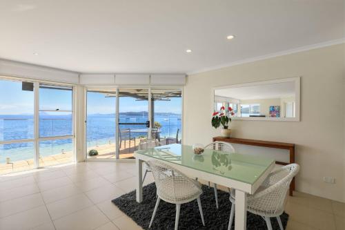a dining room with a table and a view of the ocean at Villa Maris in Soldiers Point