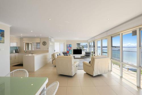 a living room with white furniture and a view of the ocean at Villa Maris in Soldiers Point