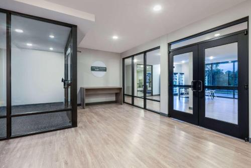 an empty lobby with glass doors and wooden floors at ECHO Suites Extended Stay by Wyndham Johnson City Medical CR in Johnson City