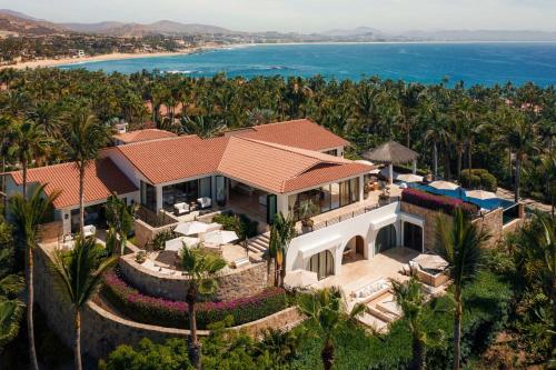 an aerial view of a house with palm trees and the ocean at One&Only Palmilla in San José del Cabo