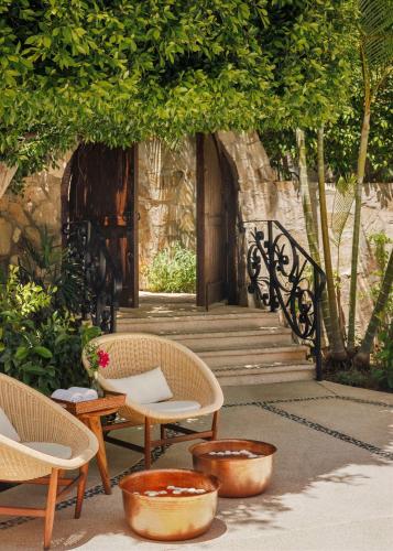 a group of chairs and tables in front of a building at One&Only Palmilla in San José del Cabo