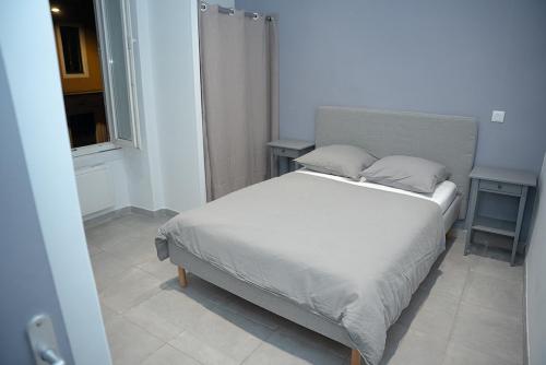 a bedroom with a bed with two pillows and a window at Appartement en plein centre de Nîmes in Nîmes