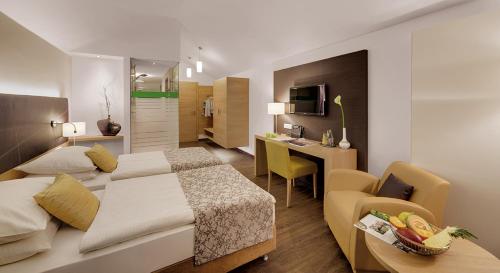 ein Schlafzimmer mit einem Bett und einem Schreibtisch in einem Zimmer in der Unterkunft Hotel Holl in Schongau