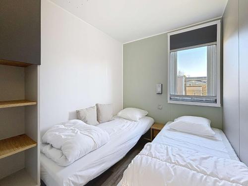 deux lits dans une petite pièce avec une fenêtre dans l'établissement Mobil-home confort, 2 chambres, piscine chauffée, 200m plage, centre-ville, parking, WiFi, ménage inclus - FR-1-361A-28, à Jullouville
