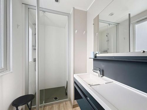 une salle de bain avec un lavabo et un miroir dans l'établissement Mobil-home confort, 2 chambres, piscine chauffée, 200m plage, centre-ville, parking, WiFi, ménage inclus - FR-1-361A-28, à Jullouville