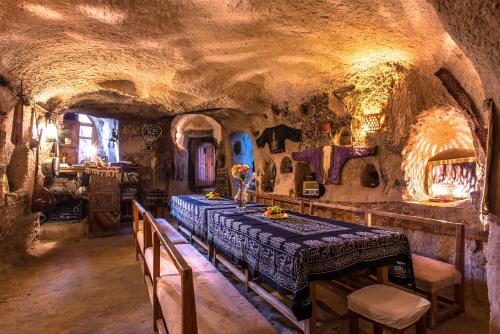 a dining room in a cave with a table and chairs at Kirkit Hotel in Avanos