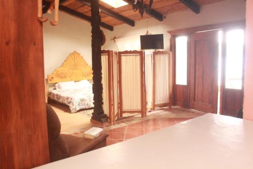 a living room with a bed and a television in it at La Pasiva de Pátzcuaro in Pátzcuaro