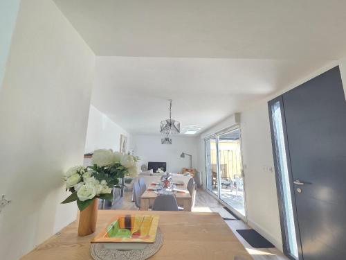 un salon avec un vase de fleurs sur une table dans l'établissement Maison de vacances à La Plaine-sur-Mer, 3 chambres, proche de la plage, jardin et plancha - FR-1-364-138, à La Plaine-sur-Mer