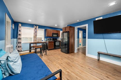 a living room with blue walls and a flat screen tv at Stylish Apartment Minutes from NRG and Med Center in Houston
