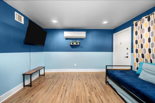 a living room with blue walls and a blue couch at Stylish Apartment Minutes from NRG and Med Center in Houston