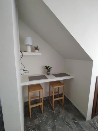 a desk with two stools and a table under a staircase at Santafe Suites in Hermosillo