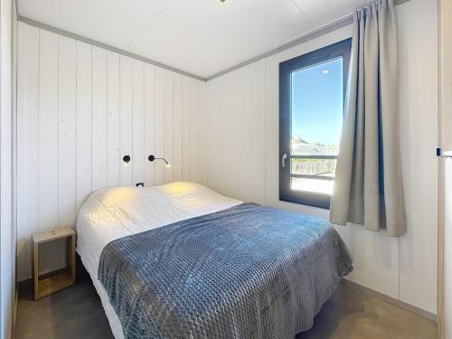 une chambre avec un lit et une fenêtre dans l'établissement Chalet de standing à Jullouville - 6 couchages, piscine chauffée, proche plage et commerces, Wi-Fi gratuit - FR-1-361-449, à Jullouville