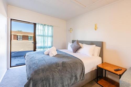 a bedroom with a bed and a large window at Lavana Motel in Hastings