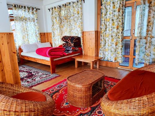 a living room with a bed and two chairs at Solitude in the Himalayas in Darjeeling
