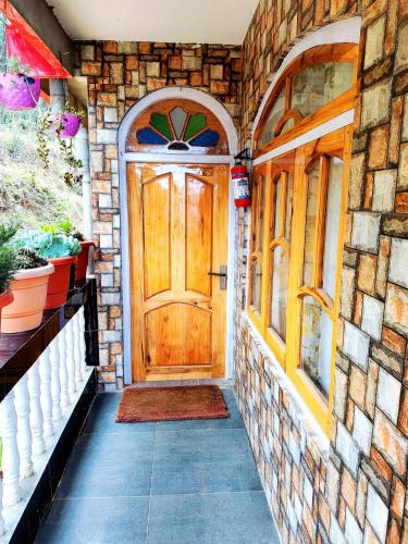 a front door of a house with a stone wall at Solitude in the Himalayas in Darjeeling