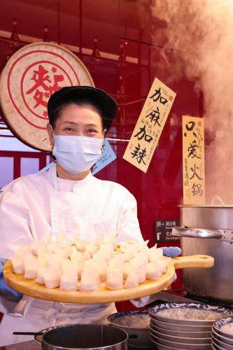 a chef wearing a mask holding a tray of food at Crowne Plaza Hangzhou Qiantang - The subway can reach the West Lake scenic area as well as the airport and high-speed rail station, adjacent to Jinsha Lake and Longfor paradise walk in Hangzhou