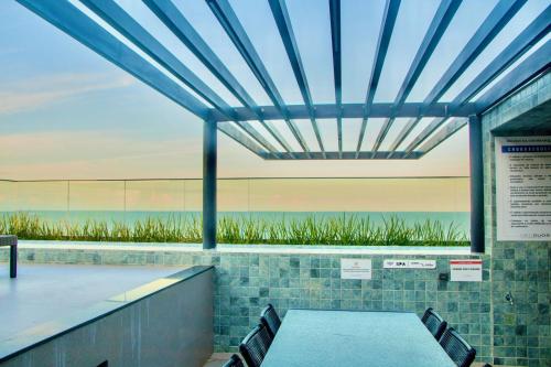 a patio with a table and chairs and a view of the ocean at Flat vista para o mar in Cabedelo