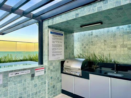 a kitchen with a sink and a counter with a window at Flat vista para o mar in Cabedelo