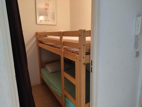 un lit superposé en bois dans une petite pièce dans l'établissement Gruissan: T2 Cabine, Piscine, Parking, Centre, 4/5 pers, Petit Budget - FR-1-796-3, à Gruissan