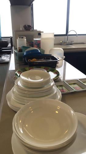 a pile of white plates sitting on a counter at Departamento 4 habitaciones 12 personas vista al mar 8vo piso Playa Almendro in Tonsupa