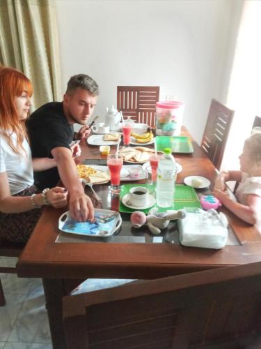 a man and woman sitting at a table with food at ASNA Homestay in Dambulla