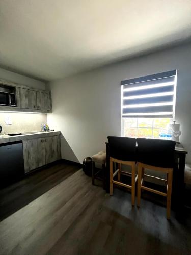 a kitchen with two chairs and a table and a window at AXEL Suites Departamento 1A in Delicias