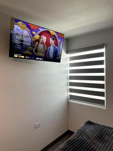a bedroom with a flat screen tv on the wall at AXEL Suites Departamento 1A in Delicias
