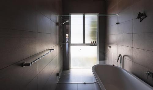 a bathroom with a bath tub and a window at Bay Properties The Chill in Yamba