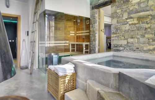 a large bathroom with a tub with a stone wall at Villa Torrecorta in Grožnjan