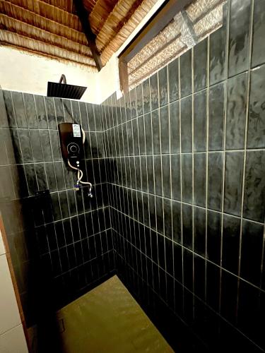 a bathroom with black tiled walls and a soap dispenser at 1511 Coconut Grove in Tioman Island