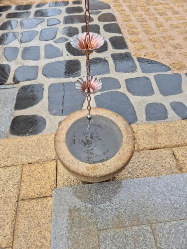 a bird feeder with a flower in a chain at Hanok Stay Seowa in Gyeongju