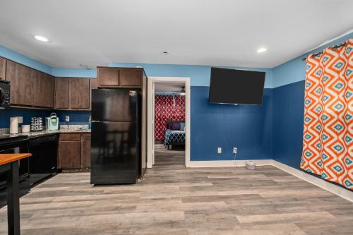 a kitchen with blue walls and a black refrigerator at 1-Bedroom Apartment Near Houston's Top Attractions with Free Park in Houston