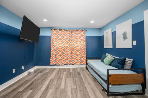 a blue room with a bed and a tv at 1-Bedroom Apartment Near Houston's Top Attractions with Free Park in Houston