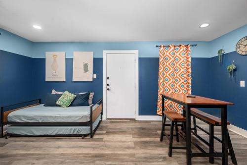 a bedroom with blue walls and a bed and a desk at 1-Bedroom Apartment Near Houston's Top Attractions with Free Park in Houston
