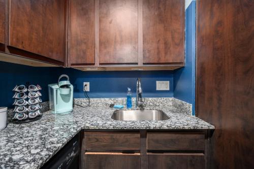 a kitchen counter with a sink and wooden cabinets at 1-Bedroom Apartment Near Houston's Top Attractions with Free Park in Houston