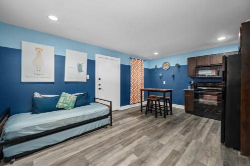 a bedroom with blue walls and a bed and a desk at 1-Bedroom Apartment Near Houston's Top Attractions with Free Park in Houston