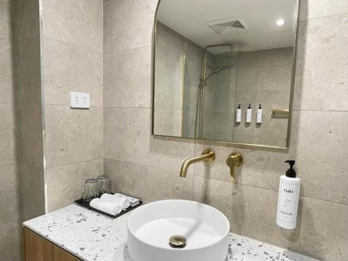 a bathroom with a sink and a mirror at Swiss-Belhotel Woolloongabba Brisbane in Brisbane