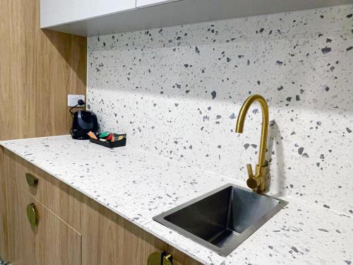 a kitchen with a sink and a granite counter top at Swiss-Belhotel Woolloongabba Brisbane in Brisbane