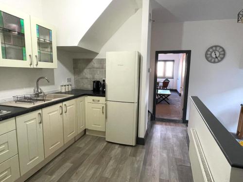 a kitchen with white cabinets and a white refrigerator at Upper Harbour Watch in Holyhead