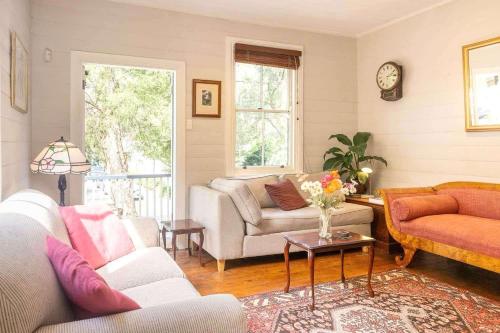 a living room with a couch and a table at Charm & History 3bdr Cottage in Waverton, close to harbour views in Sydney