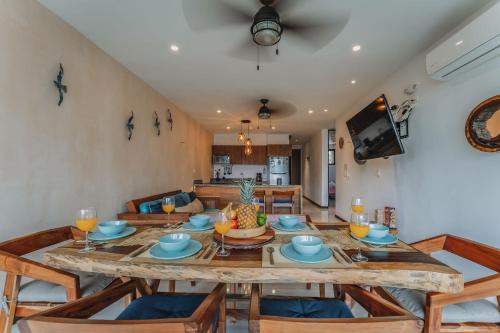 a dining room and living room with a table and chairs at Depto de Playa con vista Alberca in Chicxulub