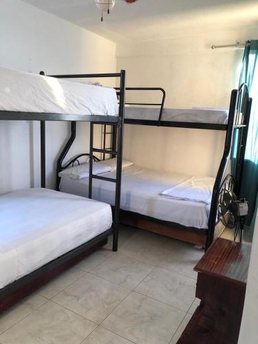 a room with three bunk beds and a table at Departamento 4 habitaciones 12 personas vista al mar 8vo piso Playa Almendro in Tonsupa