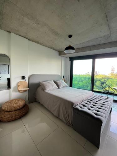 a bedroom with a large bed and a large window at Mansion Botánico Premium Buenos Aires in Buenos Aires
