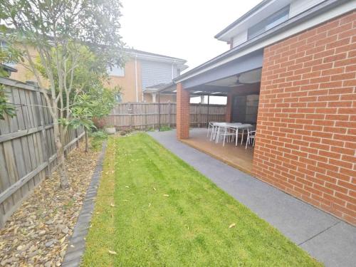 a backyard of a house with a table and chairs at Spacious Double Story Family House with Amazing City Views in Point Cook