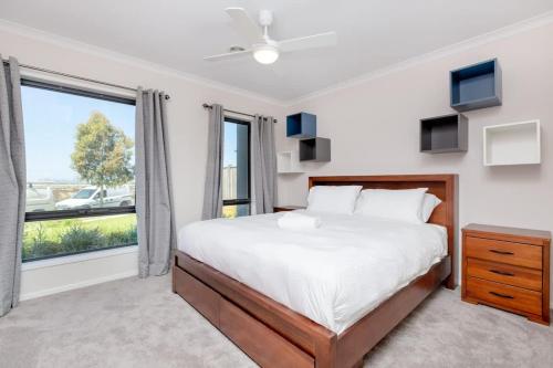 a bedroom with a bed and a large window at Spacious Double Story Family House with Amazing City Views in Point Cook
