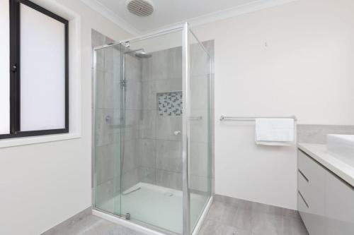 a glass shower in a bathroom with a sink at Spacious Double Story Family House with Amazing City Views in Point Cook