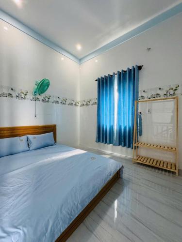 una camera da letto con un grande letto con tende blu di KEN Homestay a Cu Lao Thu