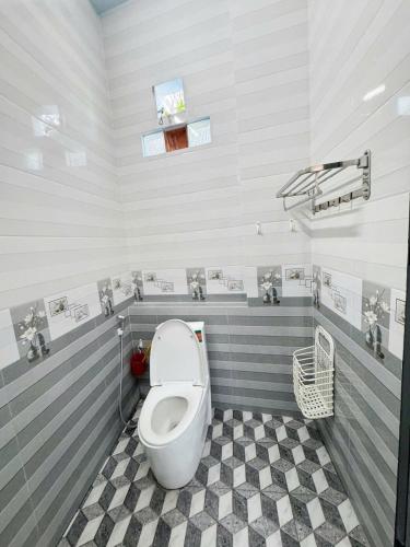 bagno con servizi igienici e pavimento a scacchi di KEN Homestay a Cu Lao Thu